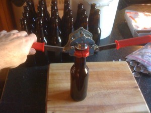 Push down on levers, crimping the cap around the edge of the bottle